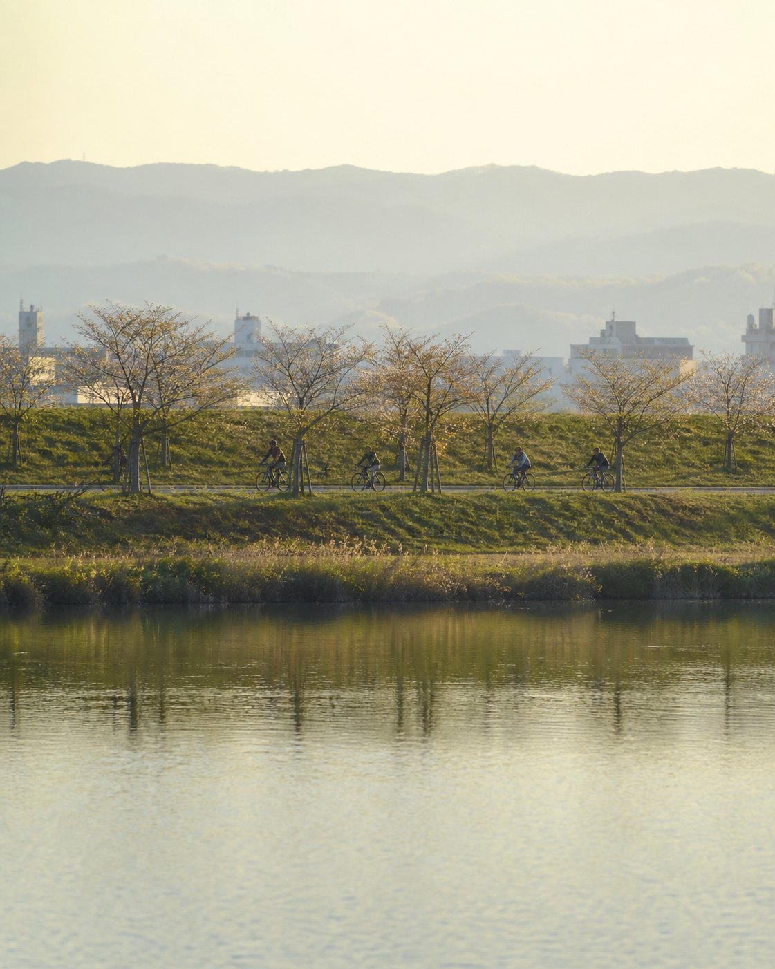 A JIMOTT group riding along the riverside towpath outside Kyoto