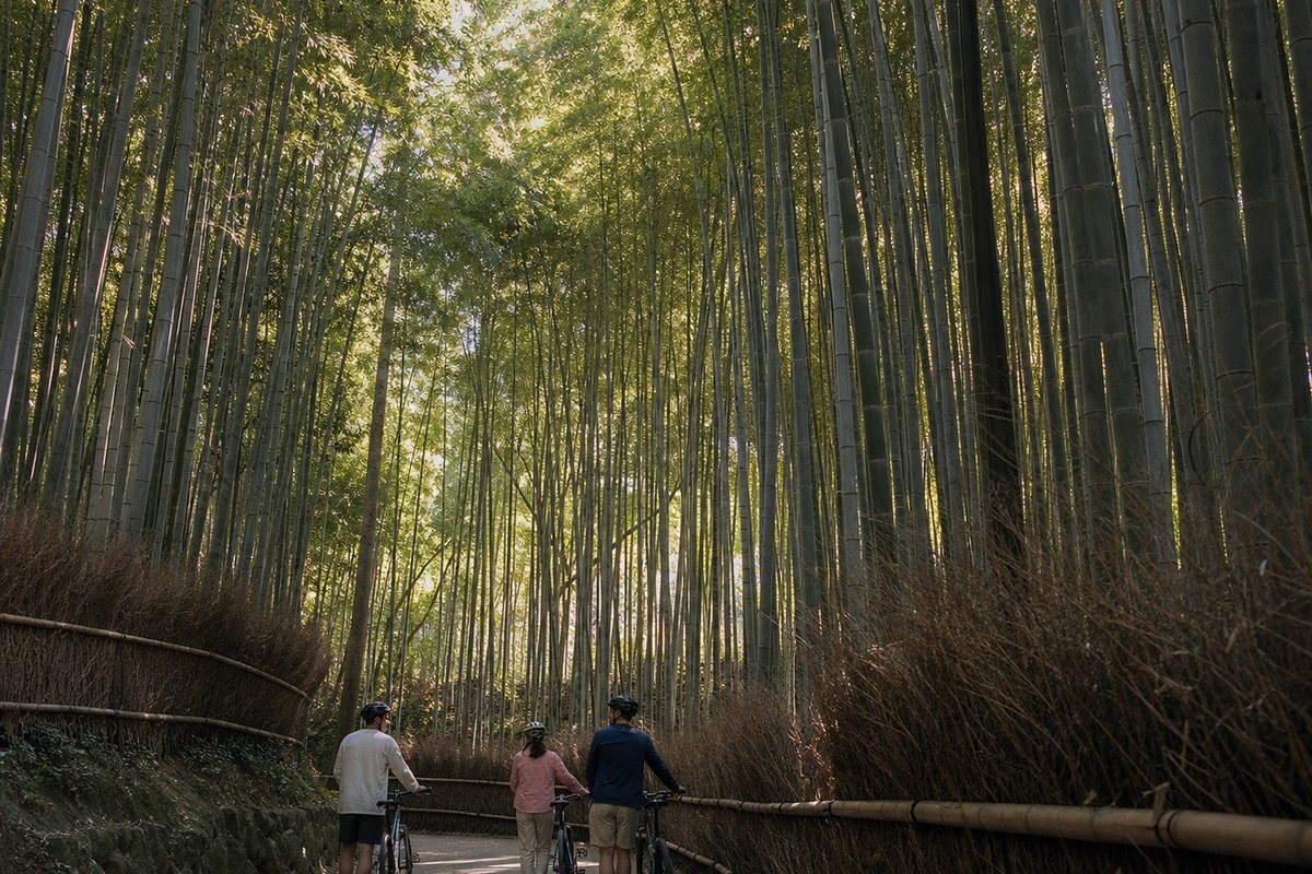 Riders on the path through the Arashiyama bamboo grove, light falling between the stems